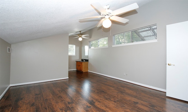 spare room featuring ceiling fan, dark hardwood / wood-style flooring, lofted ceiling, and a textured ceiling