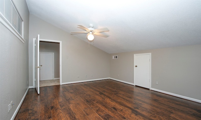 empty room with ceiling fan, dark hardwood / wood-style flooring, a textured ceiling, and vaulted ceiling