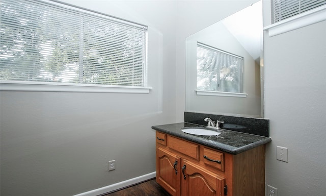 bathroom featuring hardwood / wood-style floors, vanity, and lofted ceiling