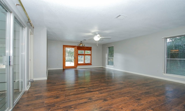 empty room with a textured ceiling, ceiling fan, and dark wood-type flooring