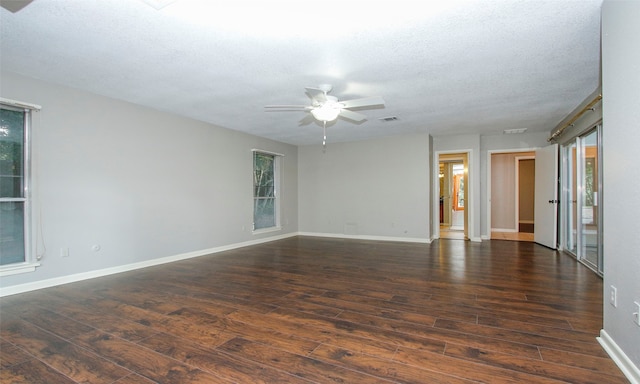 spare room with a textured ceiling, dark hardwood / wood-style floors, and plenty of natural light