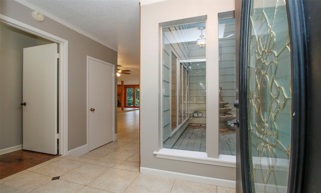 hallway featuring light tile patterned floors and a textured ceiling