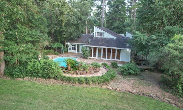 rear view of house featuring a lawn