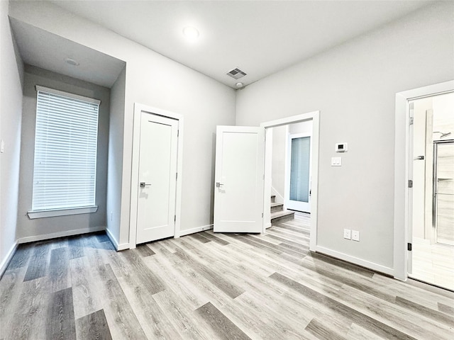 interior space with connected bathroom and light hardwood / wood-style flooring