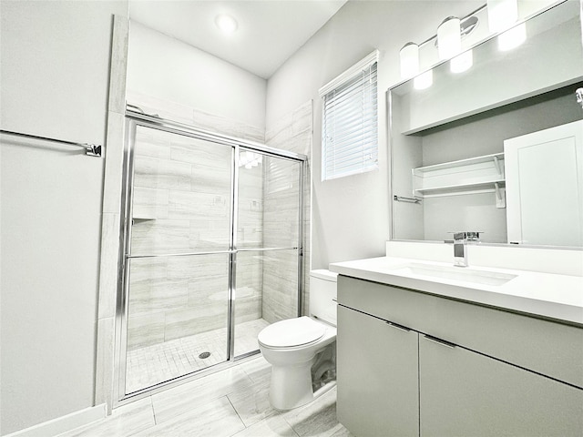 bathroom featuring vanity, toilet, and a shower with door