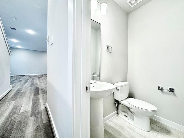 bathroom featuring hardwood / wood-style flooring, toilet, and sink