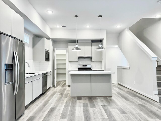 kitchen featuring decorative light fixtures, decorative backsplash, sink, and appliances with stainless steel finishes