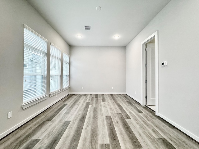 empty room with a wealth of natural light and light wood-type flooring