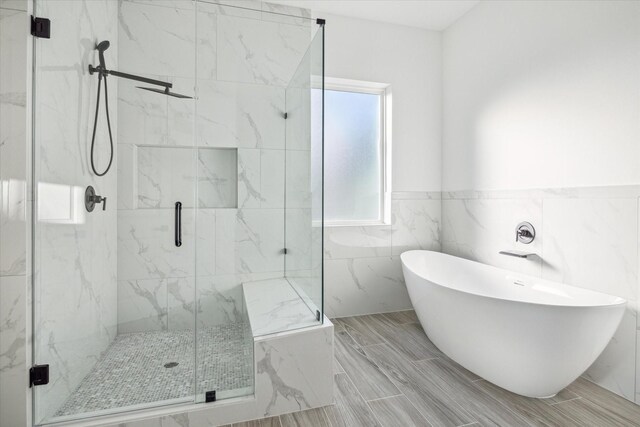 bathroom featuring independent shower and bath and tile walls