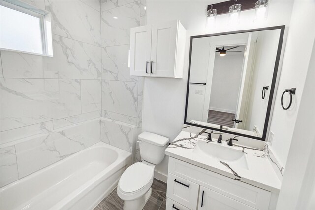 full bathroom with ceiling fan, tiled shower / bath, toilet, vanity, and hardwood / wood-style flooring