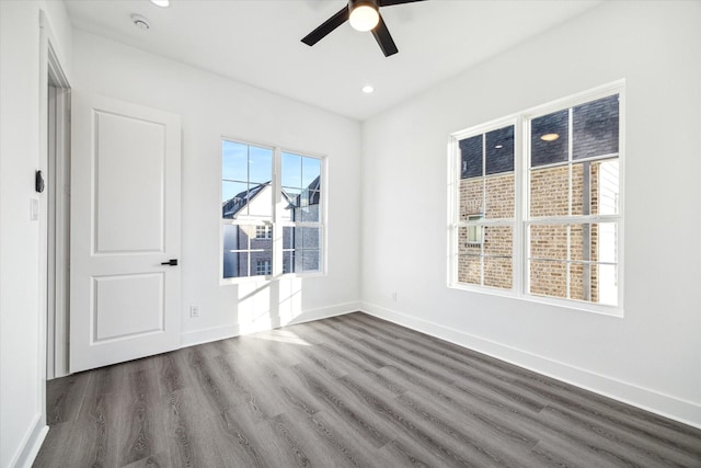 empty room with dark wood-type flooring and ceiling fan