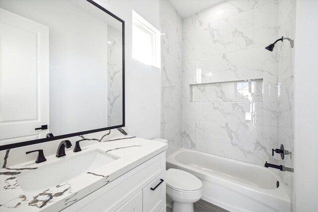 full bathroom featuring a wealth of natural light, toilet, vanity, and tiled shower / bath