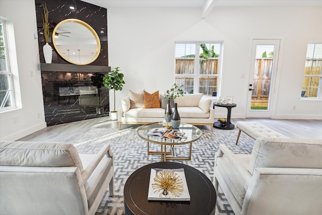 living room featuring beam ceiling, hardwood / wood-style flooring, and a premium fireplace