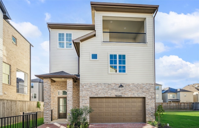 view of front of property featuring a garage, central AC, and a front yard