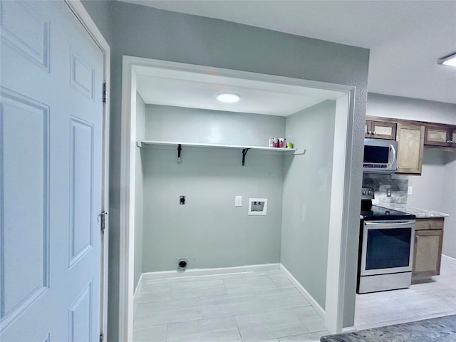 washroom featuring hookup for an electric dryer, hookup for a washing machine, and light tile patterned floors