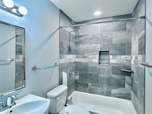 full bathroom with tiled shower / bath combo, toilet, and sink