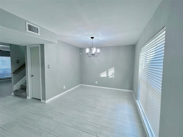 spare room with an inviting chandelier