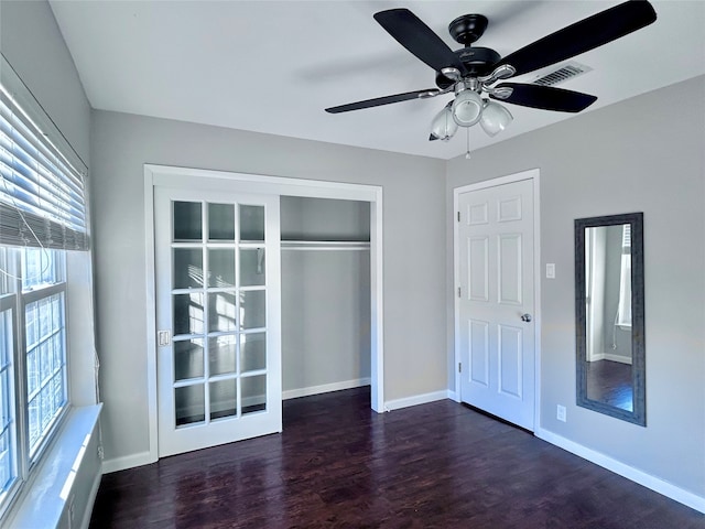 unfurnished bedroom featuring ceiling fan, dark hardwood / wood-style floors, and a closet