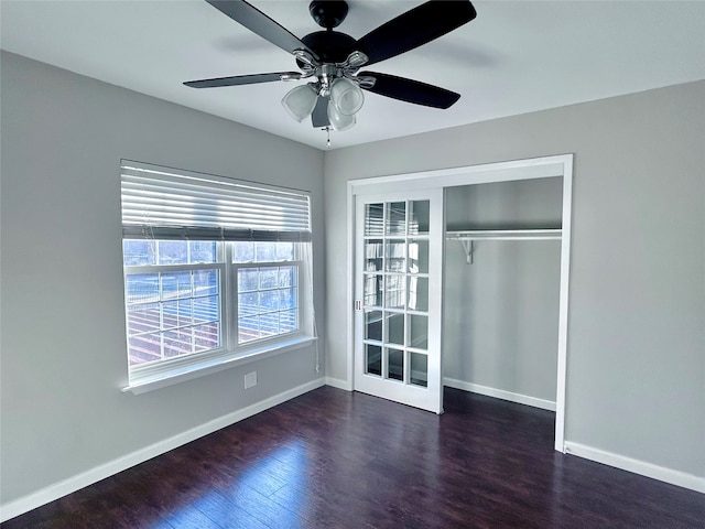 unfurnished bedroom with a closet, dark hardwood / wood-style floors, and ceiling fan