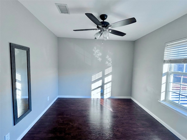 spare room featuring ceiling fan and dark wood-type flooring