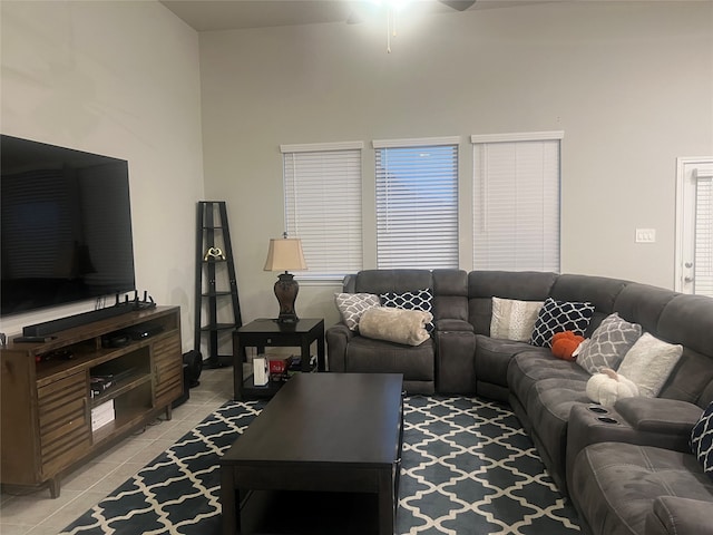 living room featuring a towering ceiling, ceiling fan, and light tile patterned flooring