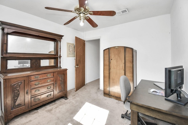 carpeted home office featuring ceiling fan