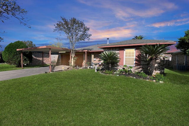 ranch-style house featuring a yard, a carport, and cooling unit