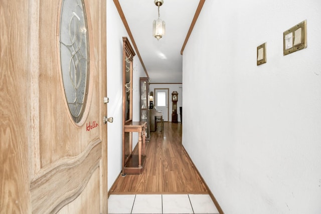 hall with wood-type flooring and ornamental molding