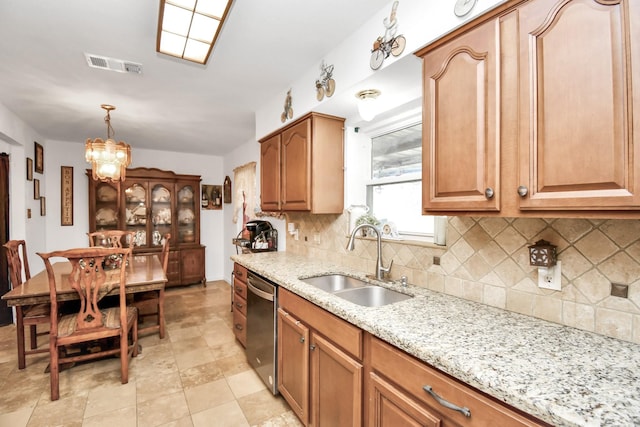 kitchen with sink, hanging light fixtures, light stone counters, stainless steel dishwasher, and a chandelier