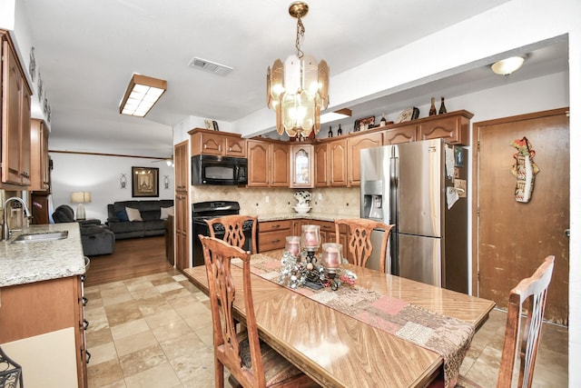 dining space featuring light hardwood / wood-style flooring, a notable chandelier, and sink