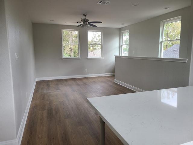 empty room with dark hardwood / wood-style floors and ceiling fan