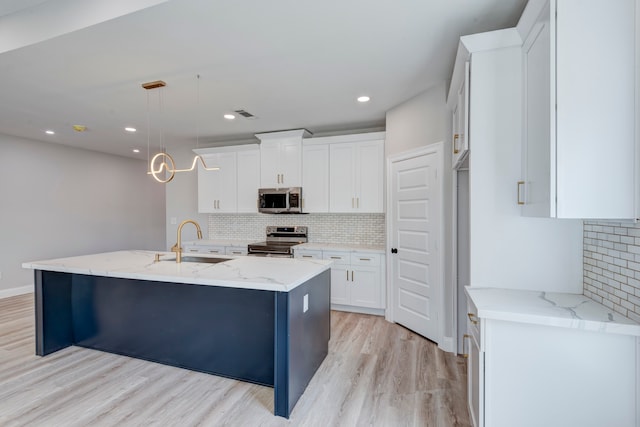 kitchen with white cabinets, decorative light fixtures, sink, and stainless steel appliances