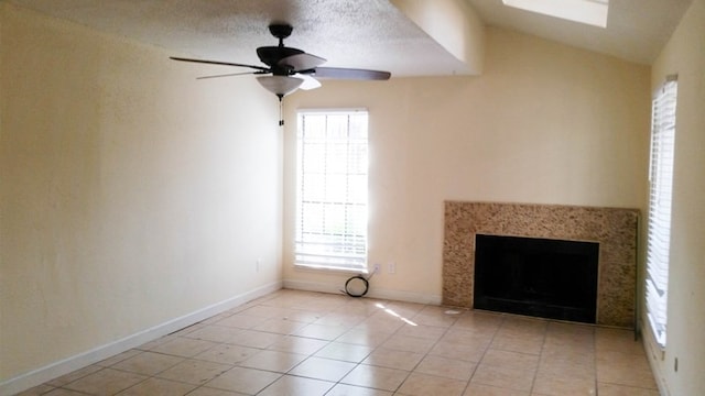 unfurnished living room featuring light tile patterned floors, a textured ceiling, vaulted ceiling, and ceiling fan