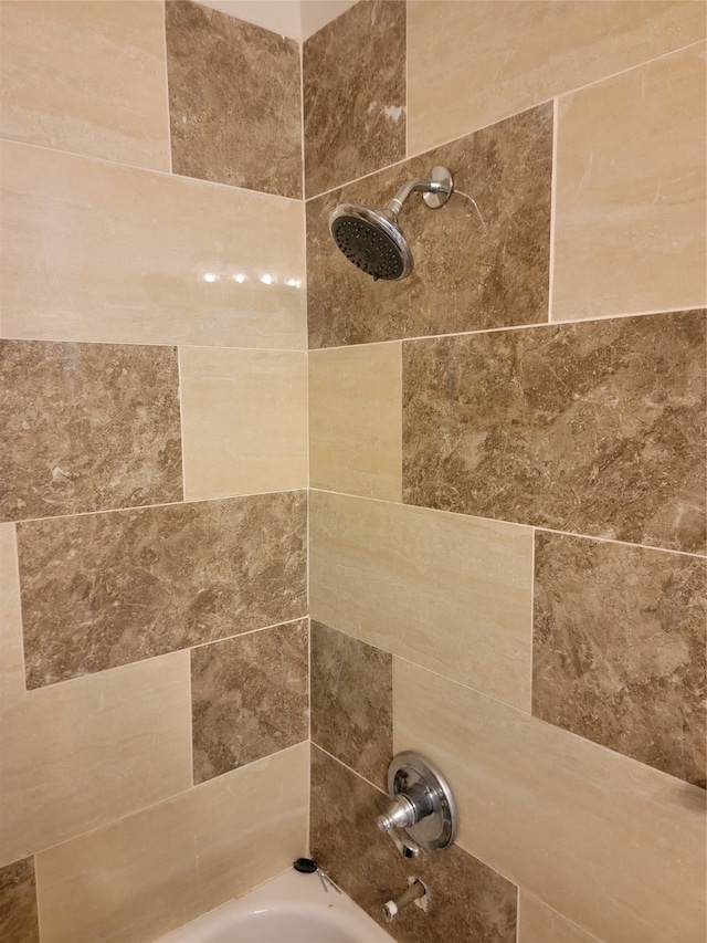 interior details with tiled shower / bath combo