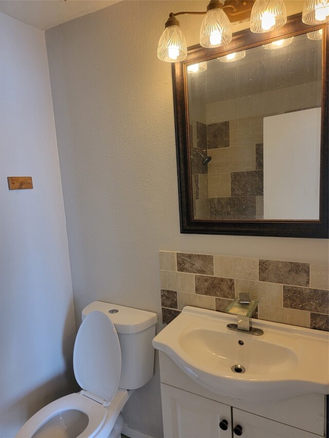 bathroom with vanity, toilet, and tasteful backsplash