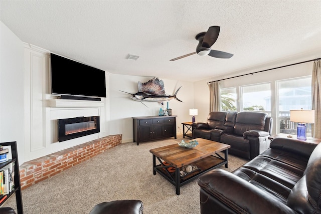 living room with a textured ceiling, ceiling fan, and light carpet