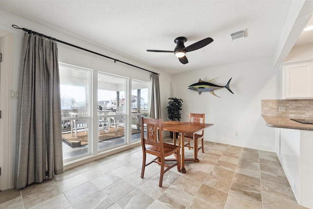 dining space featuring ceiling fan and a textured ceiling