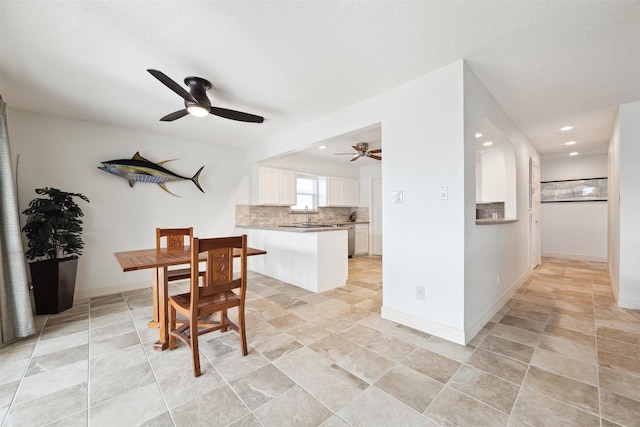 dining room with ceiling fan, sink, and a textured ceiling