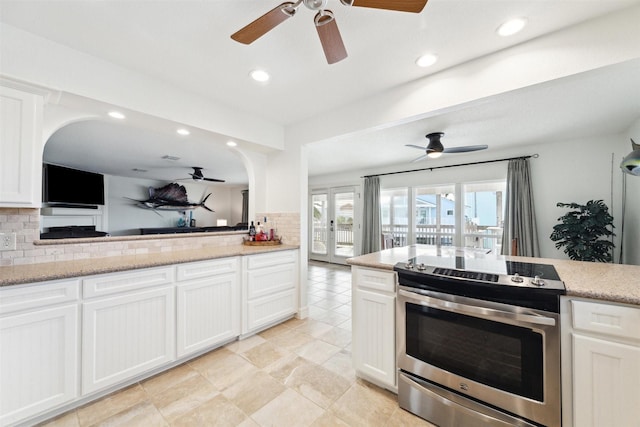 kitchen featuring white cabinets, tasteful backsplash, light stone counters, and stainless steel range with electric cooktop