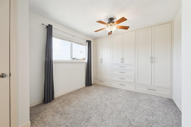 unfurnished bedroom featuring ceiling fan, light colored carpet, and a textured ceiling