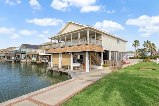 rear view of house featuring a yard and a water view