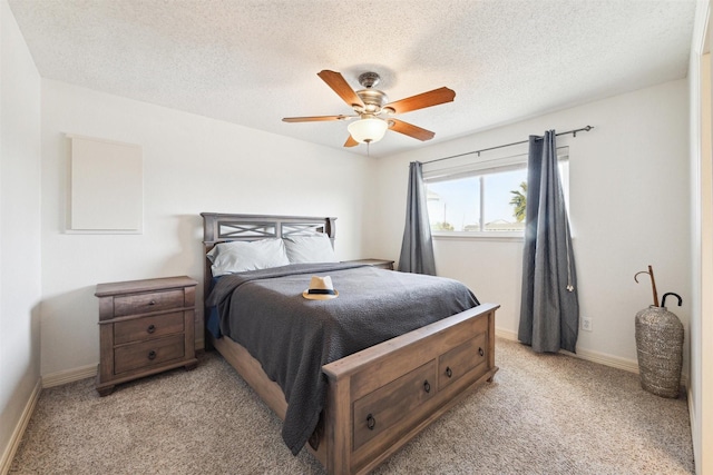 bedroom featuring light carpet, a textured ceiling, and ceiling fan