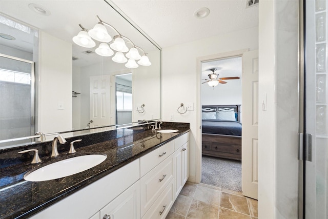 bathroom with ceiling fan, vanity, a textured ceiling, and walk in shower