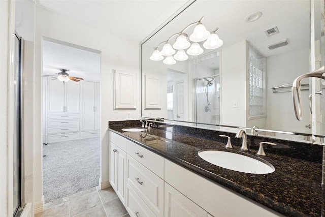 bathroom with tile patterned flooring, ceiling fan, a shower with shower door, and vanity