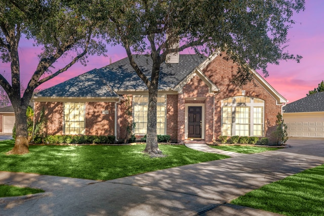 view of front of home with a yard and a garage