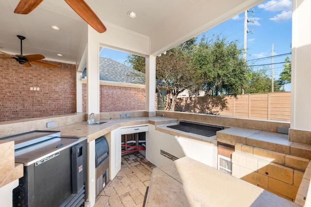 view of patio featuring ceiling fan, exterior kitchen, and an outdoor wet bar