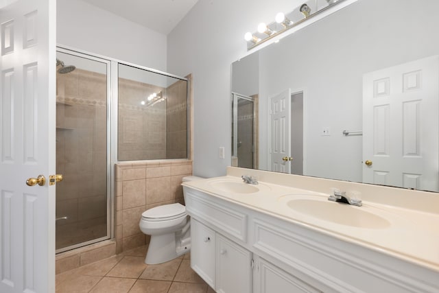 bathroom featuring toilet, vanity, tile patterned floors, and an enclosed shower