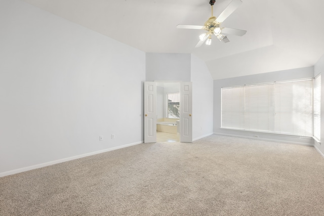 interior space featuring light carpet, vaulted ceiling, ensuite bath, and ceiling fan