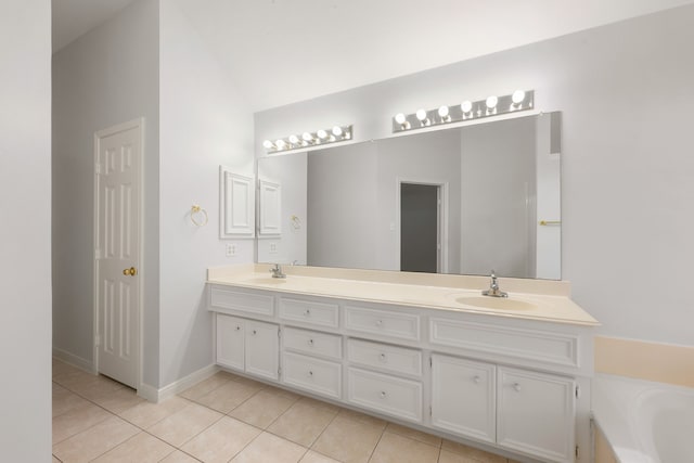 bathroom with tile patterned flooring, vanity, a bathing tub, and lofted ceiling