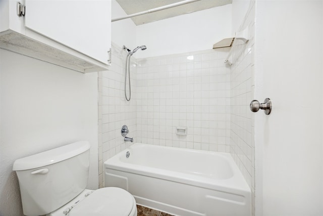 bathroom with toilet and tiled shower / bath